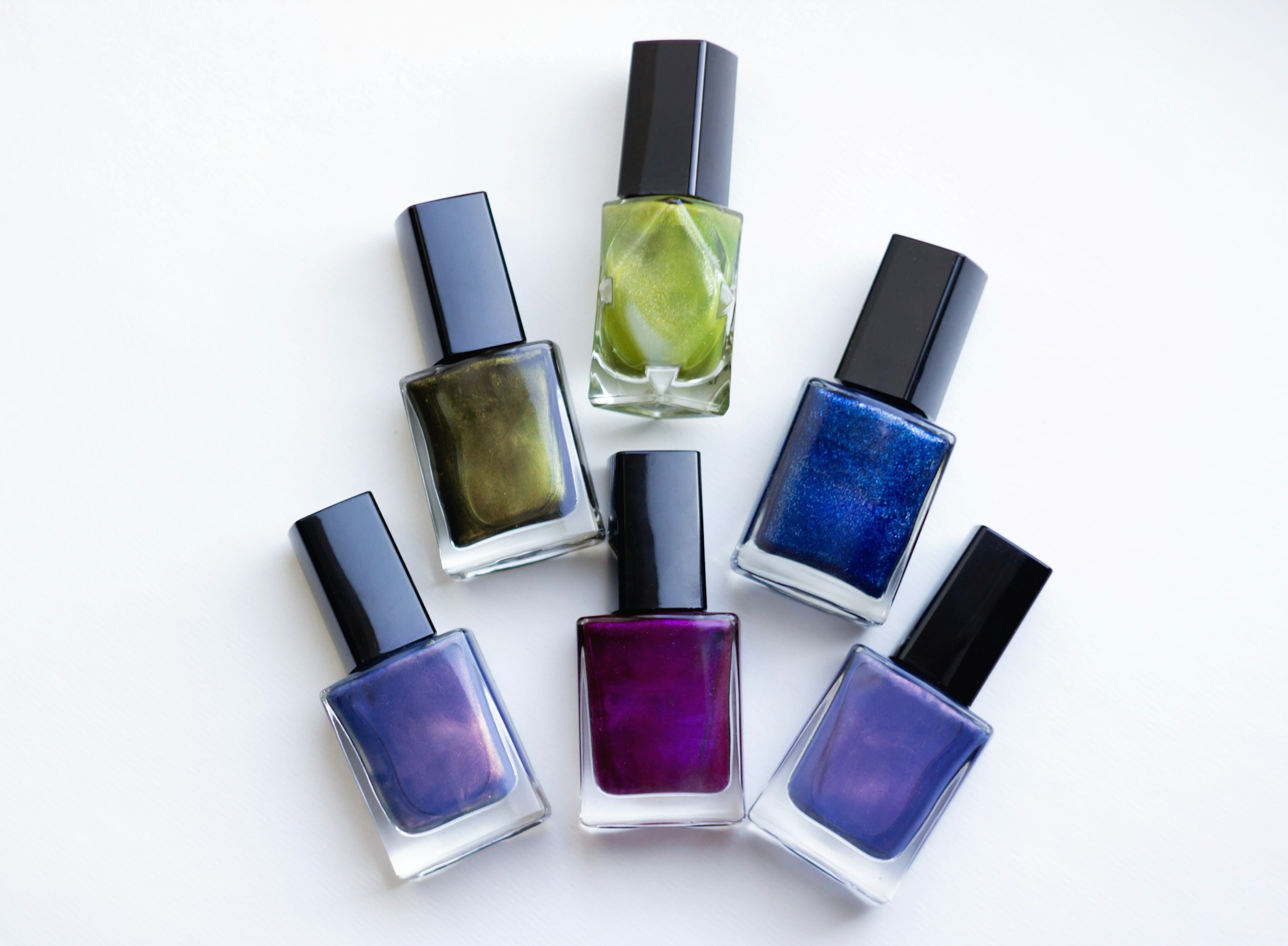 A group of five different colored nail polishes
